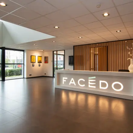 Bright office lounge area at Gildestraat 13, Velp, featuring a modern reception desk and large windows, perfect for those looking to rent office space.