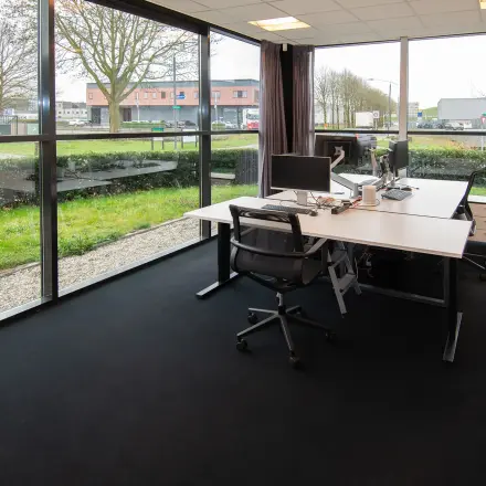 Corner office space to rent at Gildestraat 13, Velp, featuring large windows, desks, and chairs, suitable for business activities.