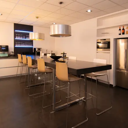 Modern furnished office space at Gildestraat 13, Velp, featuring a sleek kitchen and seating area, perfect for business gatherings.