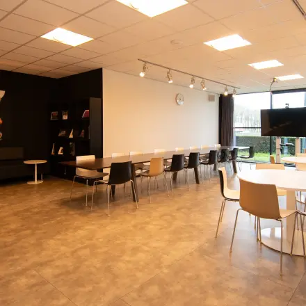 Bright office space available for rent on Gildestraat 13, Velp, featuring modern seating and a large window, ideal for workspaces.