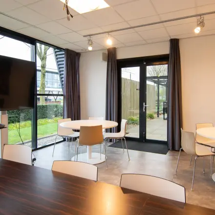 Spacious office space rental at Gildestraat 13, Velp with modern furnishings, large windows, and a welcoming atmosphere. Ideal for meetings and collaboration.