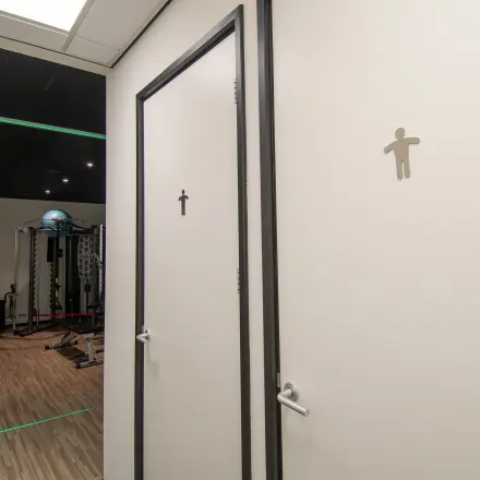Office space at Gildestraat 13 in Velp, featuring a gym area with equipment visible near restroom doors. Ideal for an office space rental with fitness facilities.