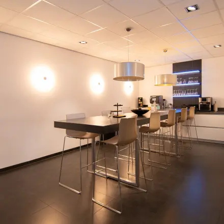 Modern office space rental at Gildestraat 13, Velp, featuring a sleek interior with high stools and a coffee area, perfect for informal meetings.