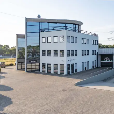 Exterior view of office space for rent at Keizersveld 47, Venray, featuring a modern building with parking area.