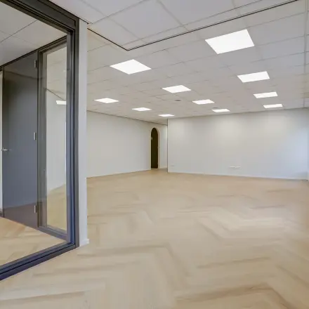 Unfurnished office space at Keizersveld 47, Venray, available for rent with large windows and wooden flooring, ideal for customization.