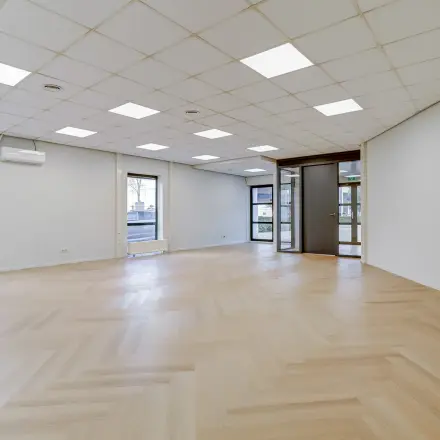 Spacious office space for rent at Keizersveld 47, Venray, featuring large windows and wooden floors, ready for customization.
