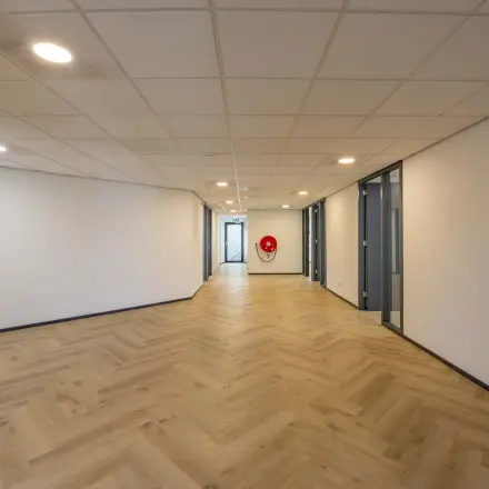 Spacious office hallway with wooden flooring and closed doors, available for office space rental at Keizersveld 47, Venray.