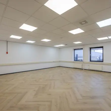 Spacious, well-lit office space with wooden flooring and ceiling lights at Keizersveld 47, Venray, ideal for office space rental.