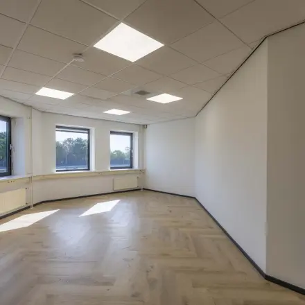 Bright office space with large windows and wooden flooring, ideal for rent office space in Venray.