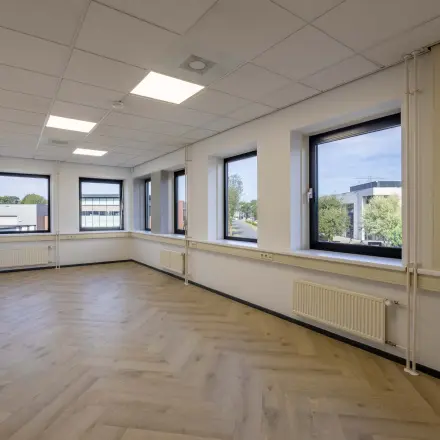 Unfurnished office space with wood flooring and large windows at Keizersveld 47 in Venray, available for rent.