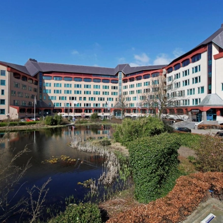 Office building exterior at Loire 104 - 206, Voorburg, with a pond in front and ample parking space available for office space rental.