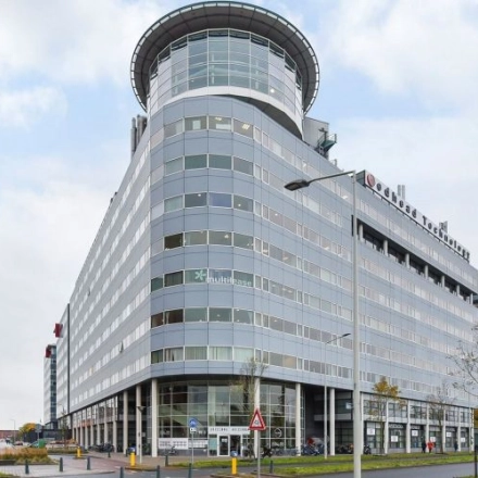 Exterior view of the modern office building at Regulusweg 11, Voorburg, featuring large windows and a sleek design. Ideal for businesses seeking office space rental in a prominent location.