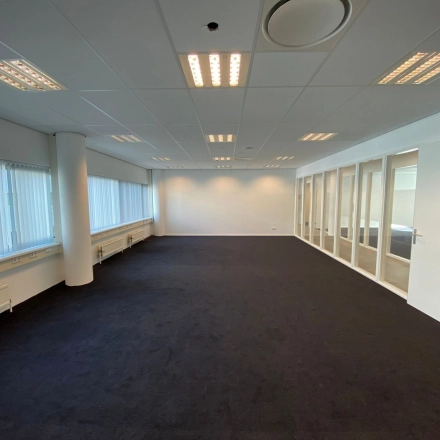 Spacious office to rent at Regulusweg 11, Voorburg, featuring large windows, neutral decor, and ample lighting, ideal for versatile workspace configurations.
