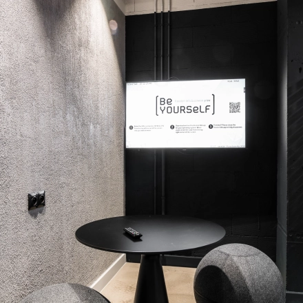 Modern office space to rent at Konstruktorska 11, Warsaw Mokotow featuring a stylish small workspace with a round table and seating.