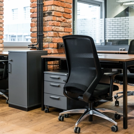 Modern office space with brick accents and sleek furniture at Konstruktorska 11, Warsaw Mokotow. Ideal for efficient workspace rental.