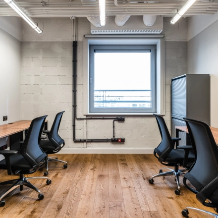 Furnished office space for rent at Konstruktorska 11, Warsaw Mokotow, featuring multiple workstations and modern lighting.