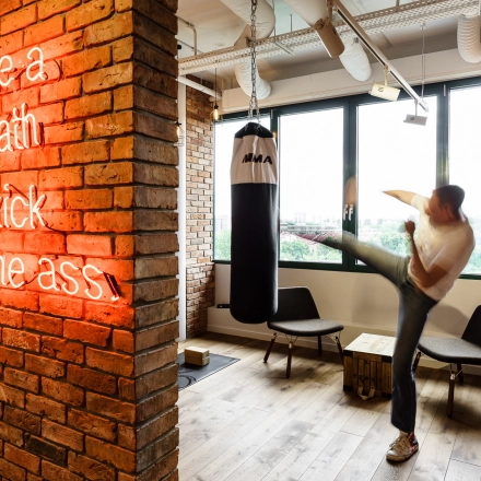Office space rental at Al. Jerozolimskie 181B, Warsaw Ochota features a modern interior with a punching bag and motivational neon sign, suited for energetic work environments.