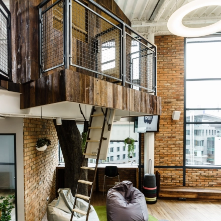Office space rental at Al. Jerozolimskie 181B features a modern interior with a unique loft-style meeting area and cozy seating, ideal for collaborative activities in Warsaw Ochota.