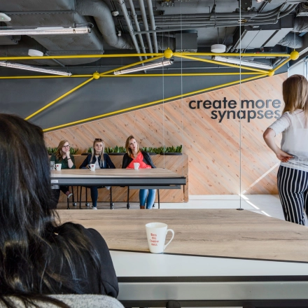 A team engaged in a meeting in a modern office, located at Al. Jerozolimskie 181B, Warsaw Ochota. Ideal for office space rental with collaborative work areas.