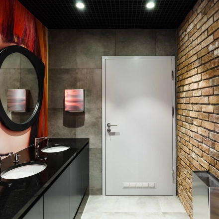 Modern restroom with brick accent wall and stylish decor at Al. Jerozolimskie 181B, Warsaw Ochota, ideal for office space rental.