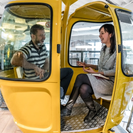 People having a business meeting in a gondola-style seating in an office to rent at Al. Jerozolimskie 181B, Warsaw Ochota.