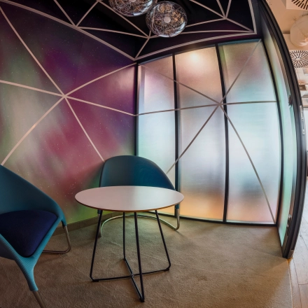 Modern, furnished meeting area in an office space at Al. Jerozolimskie 181B, Warsaw Ochota. Perfect for office space rental with stylish chairs and colorful walls.