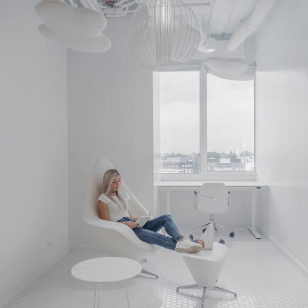 Bright office to rent at Al. Jerozolimskie 181B, Warsaw Ochota, featuring a modern, minimalist workspace with a woman working on a laptop.
