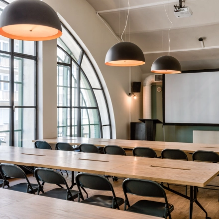 Spacious, well-lit conference room at Koszykowa 61, Warsaw Śródmieście, ideal for office space rental, featuring large windows, modern lighting, and ample seating for productive meetings.