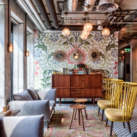 Stylish office space at Koszykowa 61, Warsaw Śródmieście with cozy seating, patterned walls, and modern lighting, perfect for office space rental.