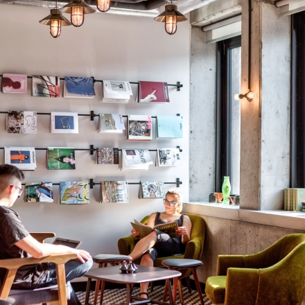 Two people relax in a cozy lounge area with modern decor at an office space rental on Koszykowa 61, Warsaw Śródmieście.