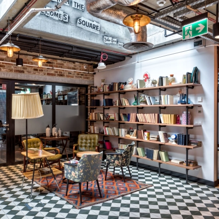 Cozy furnished office space with vintage decor and bookshelves at Koszykowa 61, Warsaw Śródmieście, ideal for office space rental.