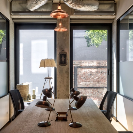 Modern office space on Koszykowa 61 in Warsaw Śródmieście with a large table and stylish lamps, ideal for meetings. A perfect office to rent for professionals.