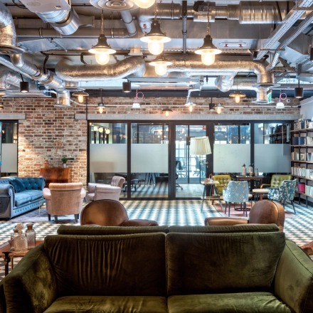 Stylish office to rent at Koszykowa 61, Warsaw Śródmieście with eclectic furnishings and exposed ceilings, perfect for office space rental activities.