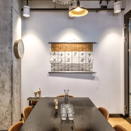 Modern office space rental at Koszykowa 65, Warsaw Śródmieście, featuring a cozy meeting area with a large table, chairs, and stylish decor.