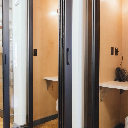Interior view of furnished office space at Krakowskie Przedmieście 13, Warsaw Śródmieście, showcasing individual work booths with phones, ideal for office space rental.