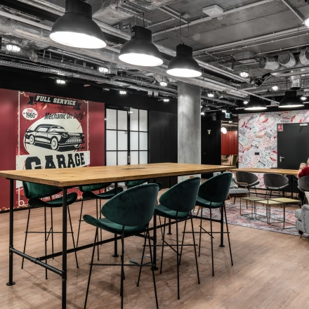 Stylish office interior with modern decor at Plac Trzech Krzyży 10/14, Warsaw Śródmieście, featuring a collaborative seating area and high tables for office space rental.