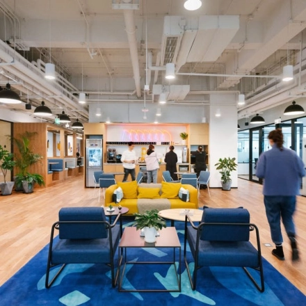 Modern workspace at Grzybowska 60, Warsaw Wola, featuring contemporary furniture and individuals engaged in collaborative business activities.