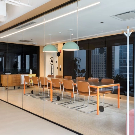 Modern office space for rent at Grzybowska 60, Warsaw Wola, featuring a sleek conference room with glass walls, stylish lighting, and contemporary furniture.