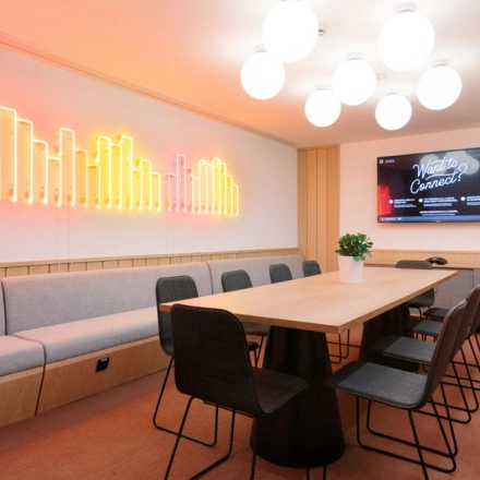 Modern office space at Grzybowska 60, Warsaw Wola with stylish lighting, long table, and chairs ideal for office space rental.