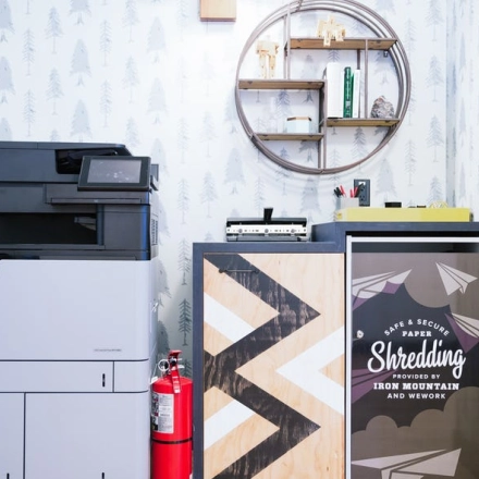 Furnished office space rental at Grzybowska 60 in Warsaw Wola featuring printing equipment and decorative shelving.