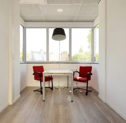 Bright office space with two red chairs and a table, ideal for office space rental at Molenweer 2, Wateringen.