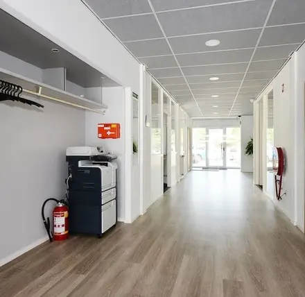 Bright hallway at Molenweer 2, Wateringen, featuring a printer and coat rack, ideal for anyone looking to rent office space.