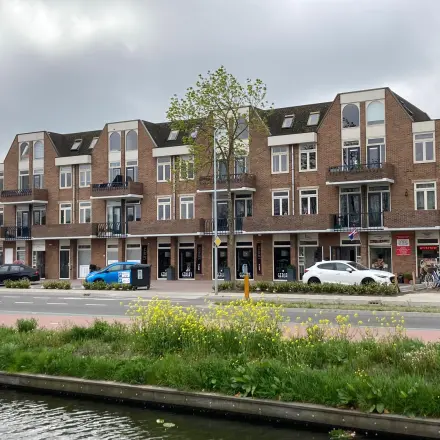 Exterior view of an office building at Boerendijk 8 in Woerden, showing multiple storefronts and parking options. Ideal spot for office space rental.