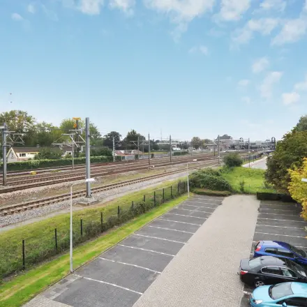A view of the parking area and nearby railway tracks from Houttuinlaan 4, Woerden, ideal for nearby office space rental.