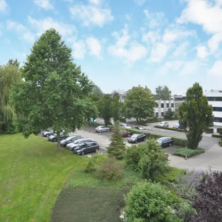 View of the office building and parking area at Houttuinlaan 4, Woerden, ideal for office space rental.