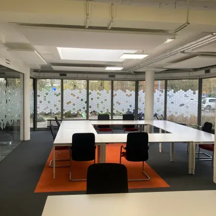 Bright office space with large windows and modern furnishings available for rent at Houttuinlaan 4, Woerden.
