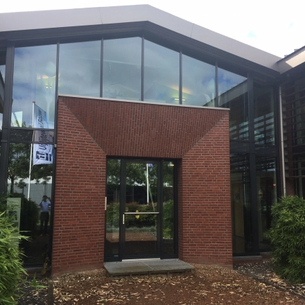 Modern exterior view of office building at M.A. Reinaldaweg 2d, Woerden, featuring large glass windows and brick facade, ideal for office space rental.