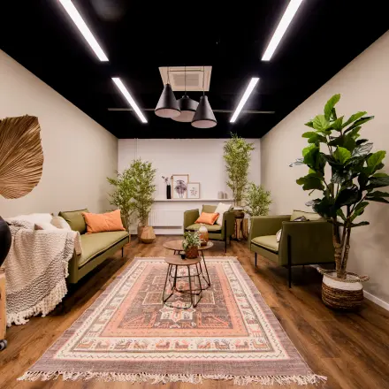 Inviting office space with modern decor, featuring comfortable seating and lush greenery, ideal for rent in Woerden.