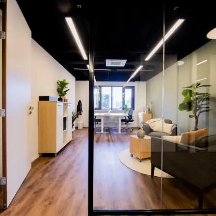 Modern office space to rent at Pelmolenlaan 16, Woerden, featuring sleek wooden flooring and comfortable furniture.