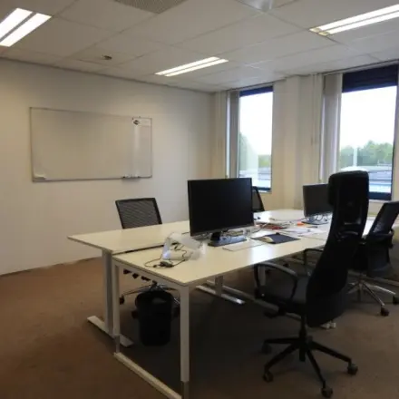 Interior office space at Pompmolenlaan 9, Woerden, featuring a furnished workspace with desks, chairs, and computer monitors, ideal for office space rental.